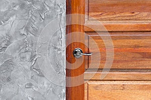 Detail of modern style metallic door handle on wooden door