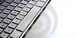 Detail of a modern white computer keyboard dirty and dusty on a white table