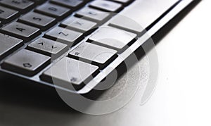 Detail of a modern white computer keyboard dirty and dusty on a white table