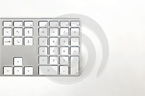 Detail of a modern white computer keyboard on a white table