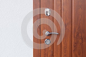 Detail of Modren style metallic door handle on wooden door.