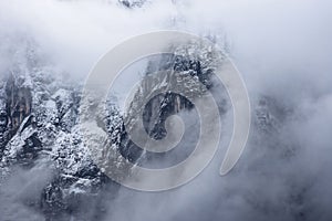 Detail of mountain face with rocks, snow and trees, in Styria region, Austria