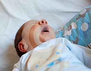 Detail of the mouth of a newborn while yawning. Selective focus on the mouth to accentuate the concept of the meaning of the yawn