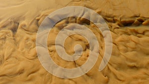 Detail of muddy whirlpools in floody stream. Messy water with soil