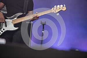 Detail of a musician playing on a bass guitar