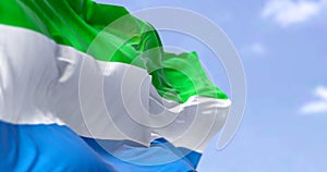Detail of the national flag of Sierra Leone waving in the wind on a clear day