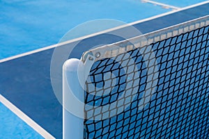 Detail of a new tennis net on a pickleball court