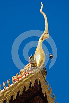 A detail of northern thai temple gable ,Chofah , under clear blue sky