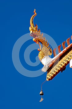 A detail of northern thai temple roof ,Naga , under clear blue sky