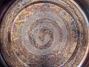 Detail of the oil stained bottom of a stainless steel pan