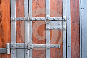 Detail of an old ancient castle wooden door with a beautiful iron knock handle.