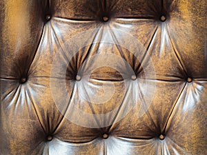 Detail of an old brown couch with buttons