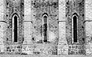 Detail of old cathedral monastery with medieval stone brick wall and elongated windows in characteristic brick gothic architecture