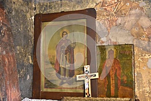 Detail from an old Christian church - The cross and icons of Saints on the ancient wall of the Orthodox temple.