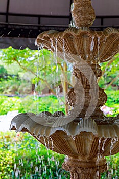 Detail of an old classic style stone fountain with flowing water