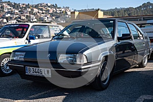 Detail of an old dark grey Citroen BX with hydropneumatic suspension.