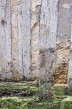 Detail of an old half-timbered house with dirty walls and weathered wood,damaged, bottom wall , abstact photo France