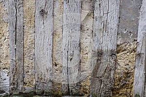 Detail of an old half-timbered house with dirty walls and weathered wood,damaged, , damaged, at the bottom of the wall