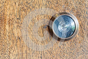 Detail of old lens peephole on wooden door background.