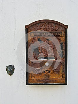 Detail of Old Metal Letter Box and Door Bell on White Stucco House