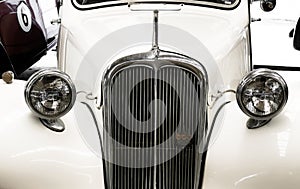 Detail of old mythic french car with radiator grille and round light