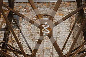 Detail of old rusty metal structure on brick wall background. Number eight. Abstract rusty background