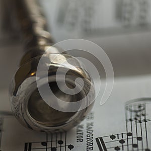 Detail of an old Silver Trumpet mouthpiece on sheet music book