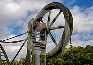 Detail of old steel cargo winch on harbour by tidal River Tamar in Devon