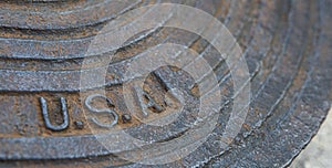 A detail of an old steel water meter cover dug out of the ground photo