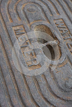 A detail of an old steel water meter cover dug out of the ground photo