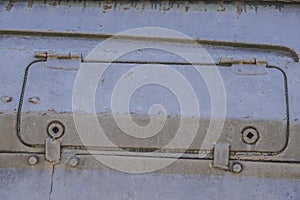 Detail of an old surface with exfoliated paint and rivets on military equipment. Military background