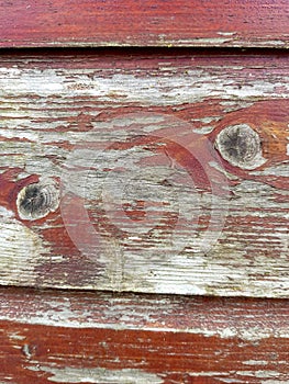 A detail of old weatherboard painted with red paint.