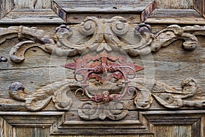 Detail of old wooden door with a knocker Catholic monastery.