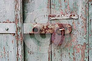 Detail of old wooden door with rusty padlock