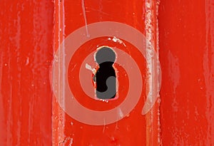 Detail of old wooden red painted door with heart shaped key hole