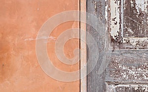 Detail of orange cement wall and wooden door texture background