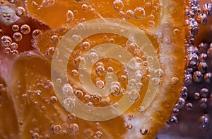 Detail of orange slice in sparkling water.