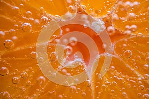 Detail of orange slice in sparkling water.