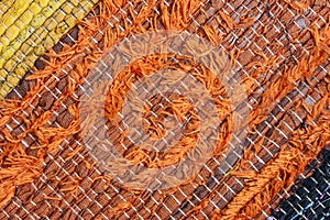 Detail of orange thread patterns on a rag rug