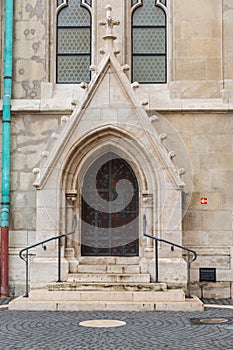 Detail of an ornate Victorian brick archway and wooden door a church.