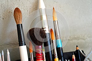 Detail of paint brushes and bright paint in an artistÃ¢â¬â¢s studio photo