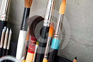 Detail of paint brushes and bright paint in artistÃ¢â¬â¢s studio photo