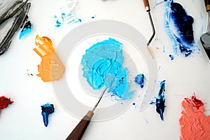 Detail of paint brushes and bright paint in an artistÃ¢â¬â¢s studio photo