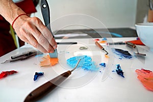 Detail of paint brushes and bright paint in an artistÃ¢â¬â¢s studio photo