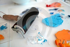 Detail of paint brushes and bright paint in an artistÃ¢â¬â¢s studio photo