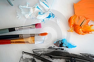 Detail of paint brushes and bright paint in an artistÃ¢â¬â¢s studio photo