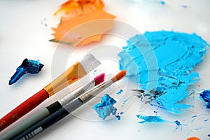 Detail of paint brushes and bright paint in an artistÃ¢â¬â¢s studio photo