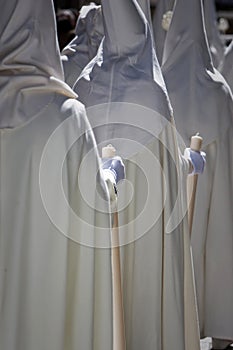 Detail penitent white holding a candle during Holy Week