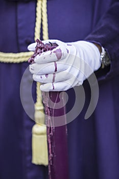 Detail penitent white holding a candle during Holy Week