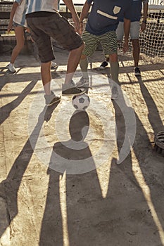 Detail of people playing football, legs kicking the ball